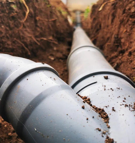Närbild på skarvade rör i marken för avlopp. Vi hjälper dig med rör och avlopp på ön.
